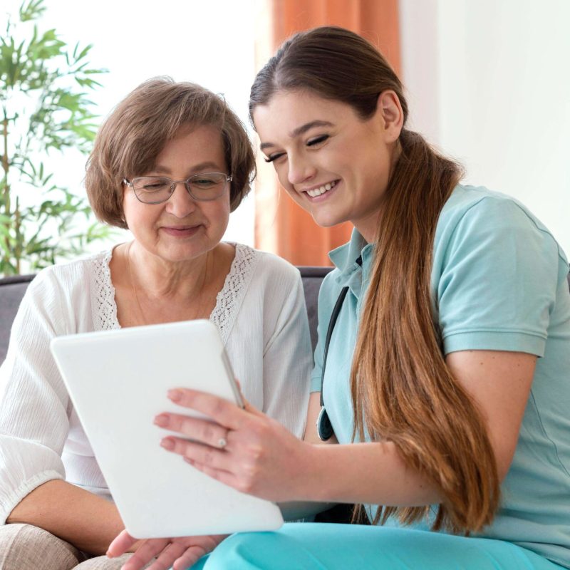 medium-shot-smiley-women-looking-tablet
